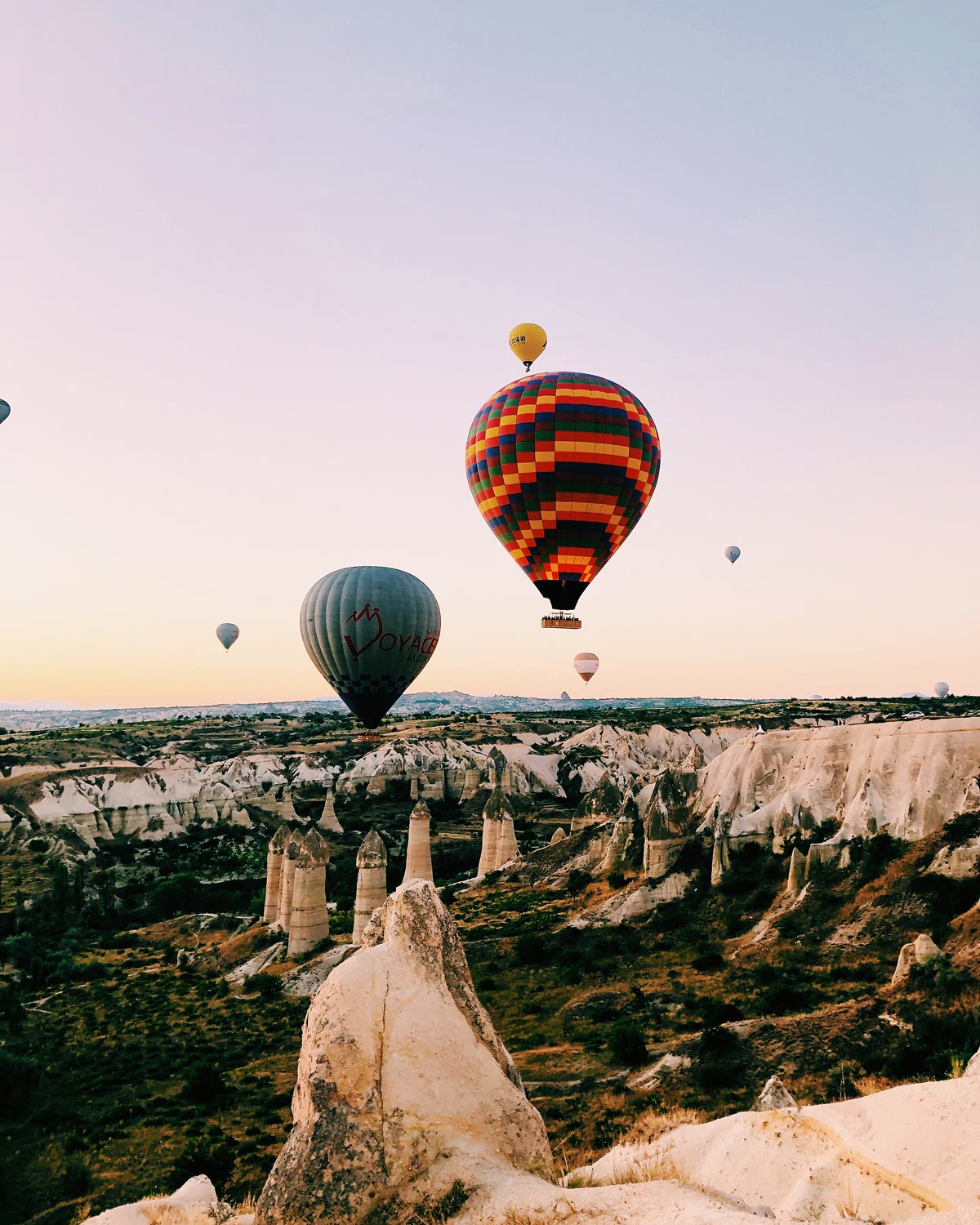 Hot air balloons rising over the valleys of Cappadocia at sunrise
