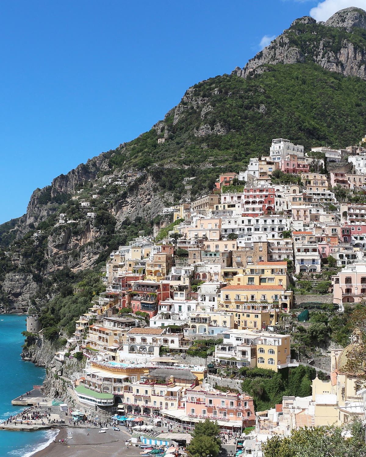Colourful houses of Positano climbing a green cliff above the turquoise sea